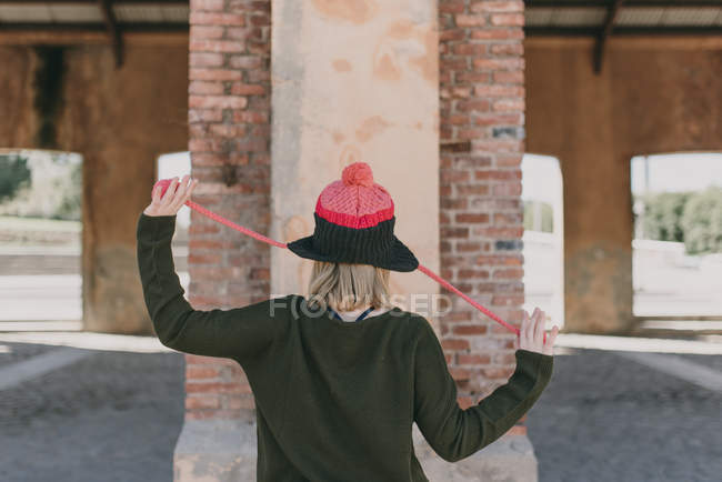 Girl in knitted hat holding hands with suspenders aside — Stock Photo