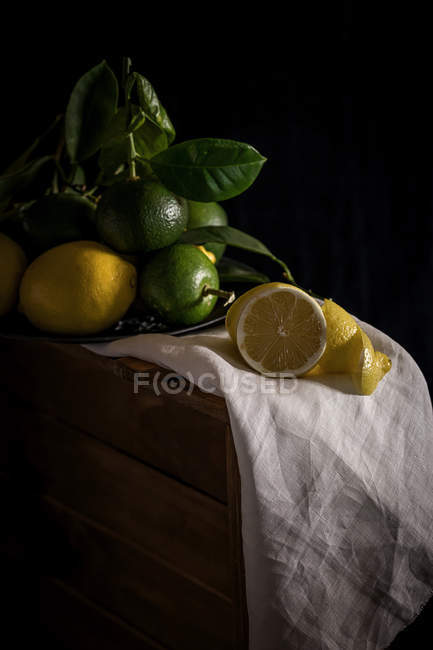 Limoni e lime con tovagliolo bianco — Foto stock