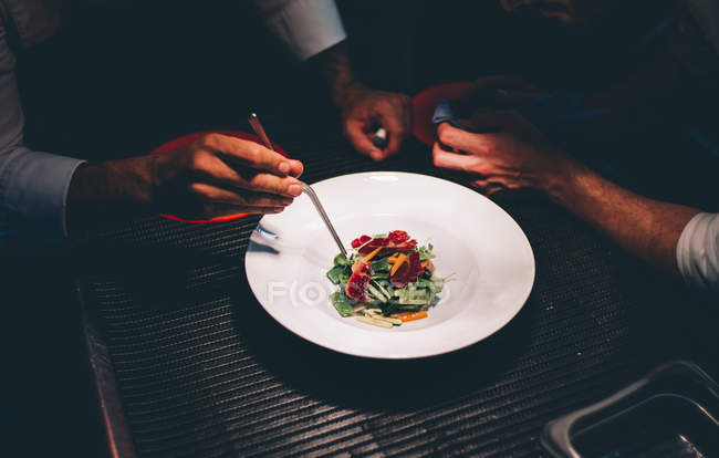Crop cook's hands decorating special dish. — Stock Photo