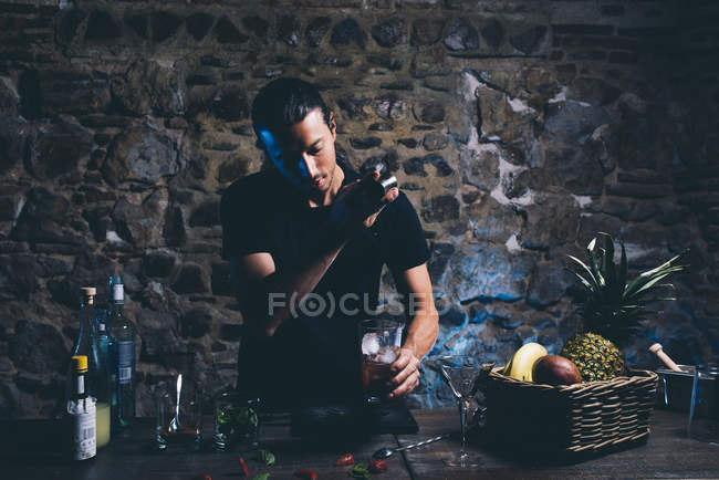 Man shaking ingridients for cocktail — Stock Photo