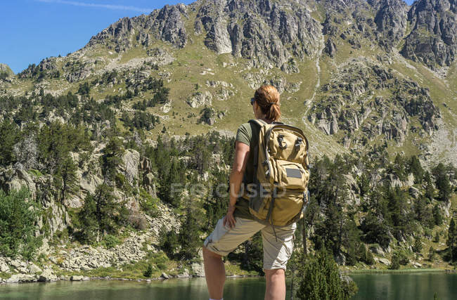 Caminante femenina posando contra el río de montaña - foto de stock