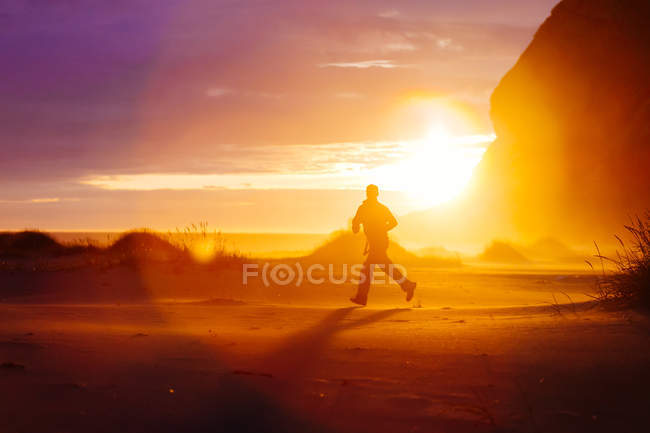 Silhueta de homem correndo na natureza ao pôr do sol luz — Fotografia de Stock