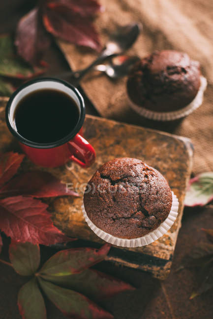 Muffins with coffee cup on book — Stock Photo
