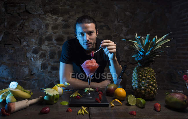 Homme ajustant fraise sur verre à cocktail — Photo de stock
