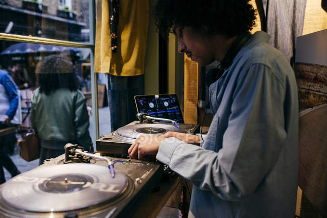ЛОНДОН, Великобритания - 4 мая 2017 года: Вид сбоку человека, играющего на DJ-консоли — стоковое фото