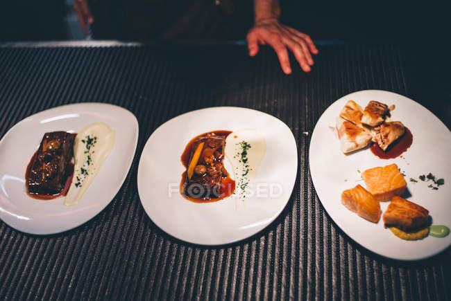 Platos con comida preparada listos para comer en el restaurante - foto de stock