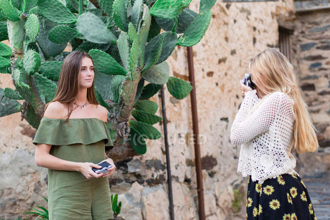 Les filles prennent des photos de gros cactus — Photo de stock