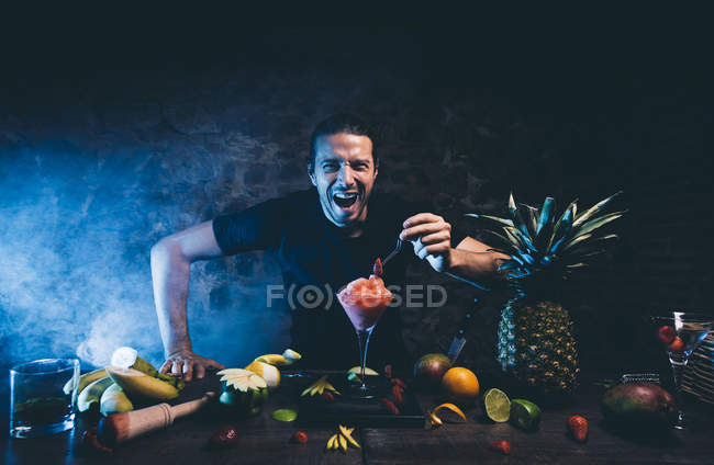 Mann bereitet Cocktail mit Erdbeere zu — Stockfoto