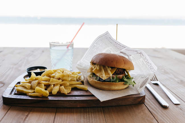 Burger and fries on wooden table. — Stock Photo