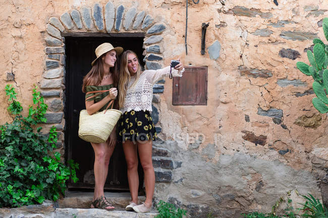 Meninas tirando selfie na fachada do prédio rural — Fotografia de Stock