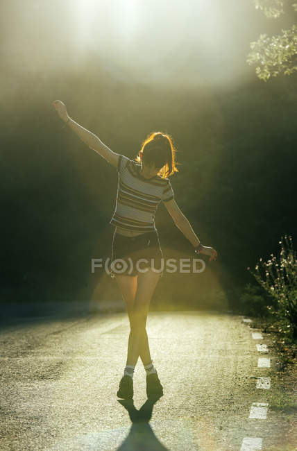 Menina andando na estrada ensolarada — Fotografia de Stock