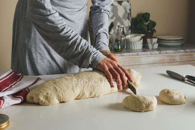 Female hands cutting dough — Stock Photo