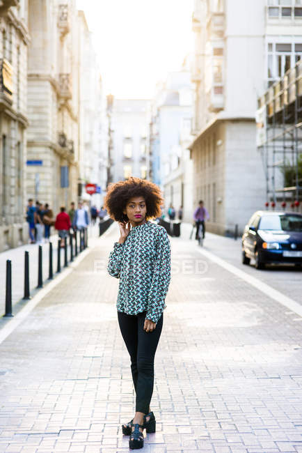 Жінка позує на вулиці і дивиться на камеру — стокове фото