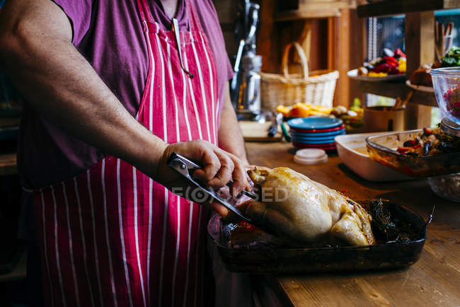 Crop male serving grilled chicken with tweezers — Stock Photo