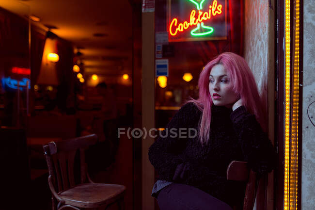 Woman sitting in armchair on a pub — Stock Photo