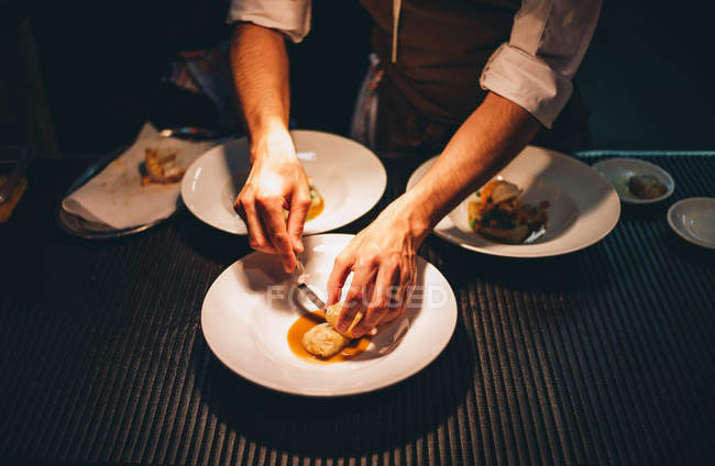 Mani che decorano piatti speciali al ristorante cucina — Foto stock