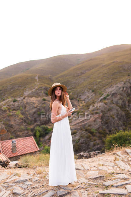 Girl with camera on top of hill — Stock Photo