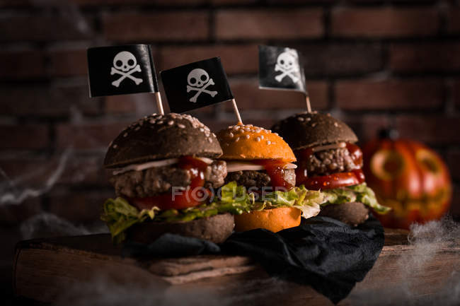 Halloween burgers with jolly roger flags — Stock Photo