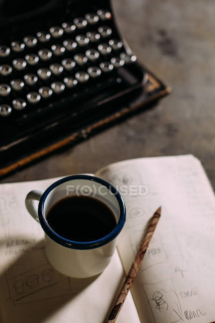 Cup with coffee on opened book — Stock Photo