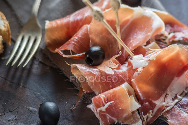 Prosciutto stagionato con pane e olive — Foto stock