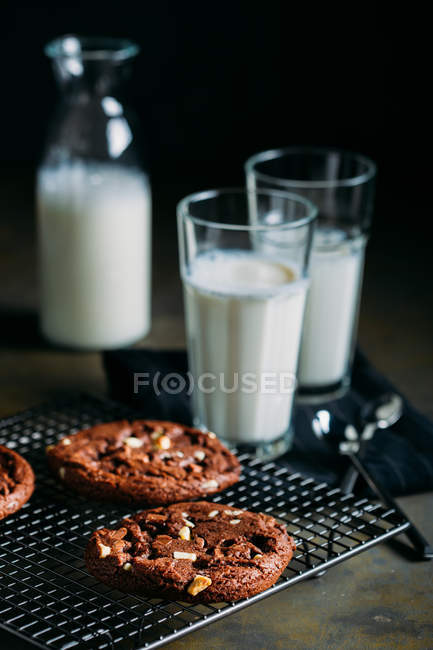 Bolinhos de chocolate e copos de leite — Fotografia de Stock