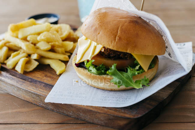 Burger und Pommes auf Holztisch. — Stockfoto