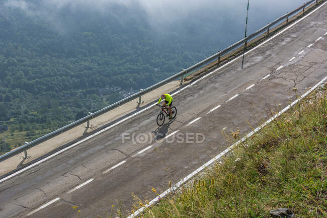 Ciclista in una strada di montagna — Foto stock