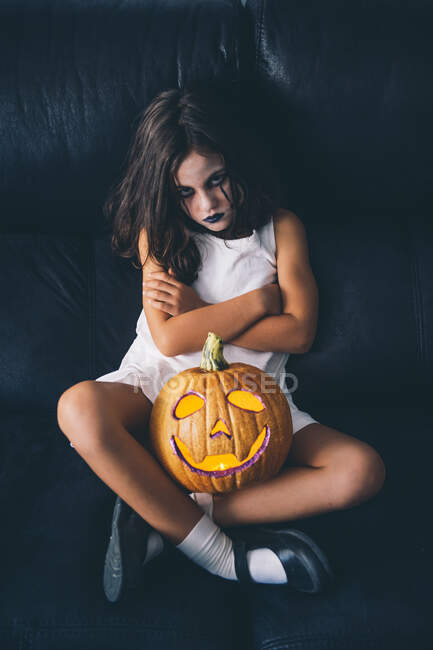 Menina maliciosa com abóbora halloween — Fotografia de Stock