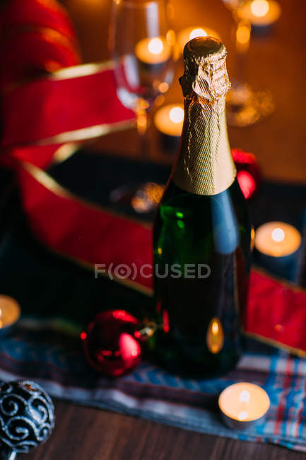 Bottle of champagne with candles — Stock Photo