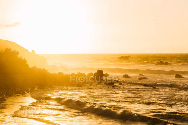 Vue panoramique des vagues lavant le littoral en plein soleil du matin . — Photo de stock