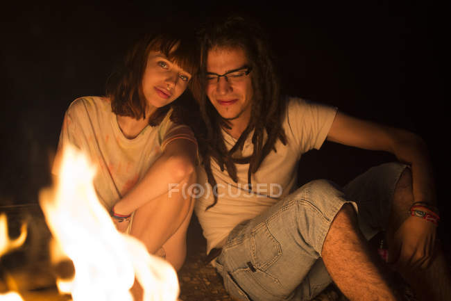 Casal sentado na fogueira — Fotografia de Stock