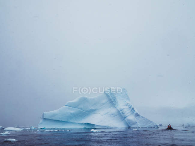 Люди пливуть у човні на льодовому озері — стокове фото