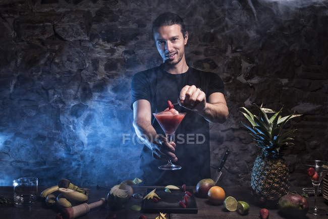 Uomo che prepara cocktail con fragola — Foto stock