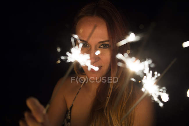 Girl holding lightening sparkler — Stock Photo
