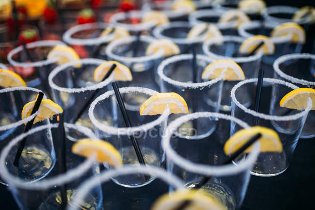 Fila de vasos vacíos con rodajas de limón - foto de stock