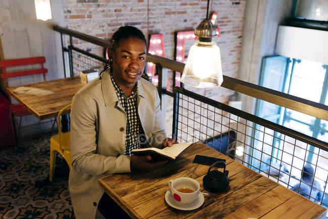 Hombre leyendo diario en la cafetería - foto de stock