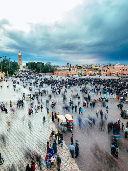 Multidão de habitantes locais e turistas na praça em Marraquexe, Marrocos — Fotografia de Stock