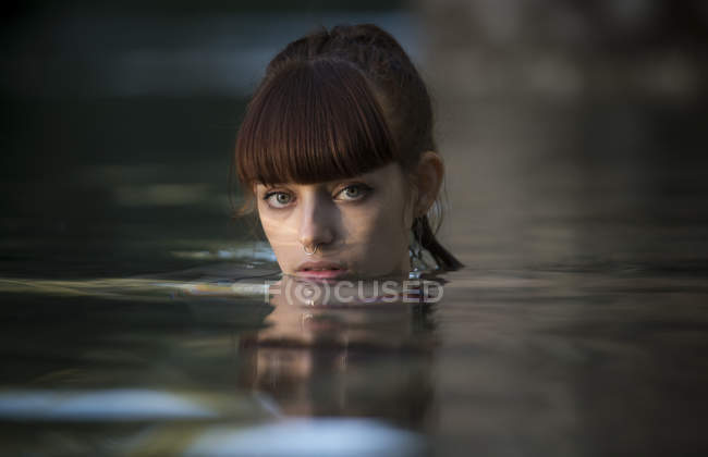 Mädchen blickt Kamera vom Wasser aus an — Stockfoto