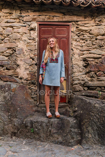 Mulher de pé na porta e olhando para a câmera — Fotografia de Stock