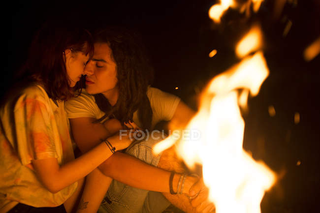 Couple cuddling  at bonfire — Stock Photo