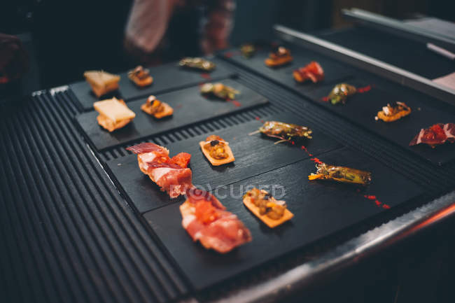 Close up  delicious snacks on square plates — Stock Photo