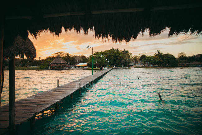 Costa con balneario tropical y muelle - foto de stock
