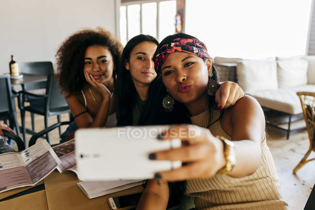 Amigos alegres tomando selfie no café — Fotografia de Stock