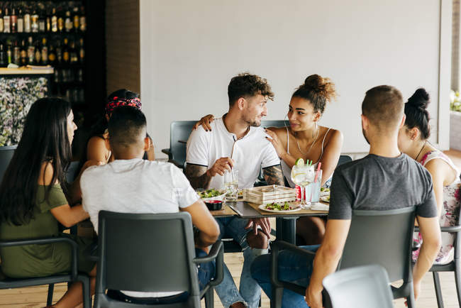 Groupe d'amis assis à table au restaurant et dînant ensemble
. — Photo de stock