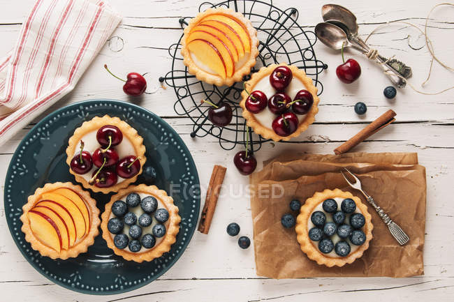 Tartaletas llenas de crema y fruta vista desde arriba - foto de stock
