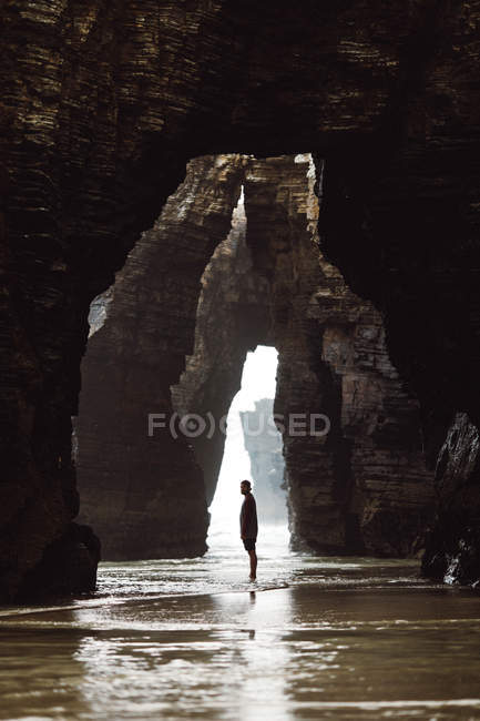 Vista à distância do homem em pé na caverna — Fotografia de Stock