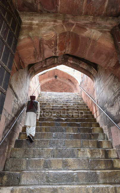 Visão traseira do homem andando no andar de cima no antigo edifício tradicional . — Fotografia de Stock