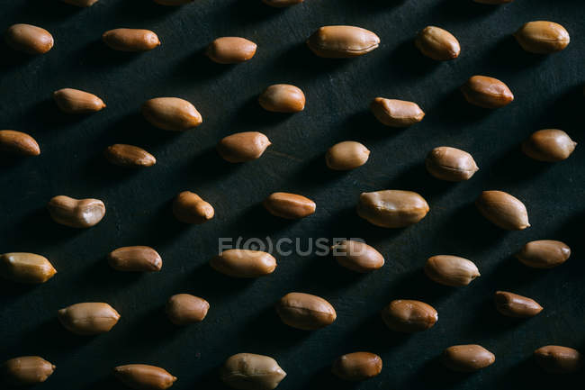 Patrón de cacahuetes en superficie oscura - foto de stock