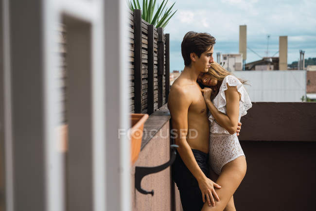 Vue latérale du couple embrassant passionnément sur la terrasse — Photo de stock