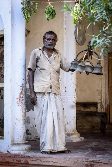 Uomo indiano in piedi con campane tradizionali sulla strada. — Foto stock